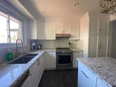 a kitchen with white cabinets and granite counter tops at Yonge and Finch Subway !L Spacious & Bright Private Bedroom with Shared Amenties in Toronto
