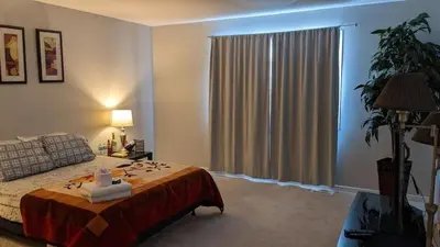 a bedroom with a bed and a large window at The Warm Welcome Suite in Thorold