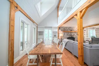 a dining room with a table and a couch at Marmora Retreat - Unique Waterfront Farmhouse in Marmora