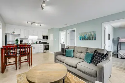 a living room with a couch and a table and a kitchen at The Alpine - Central Collingwood Condo in Collingwood