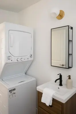 a white bathroom with a sink and a mirror at The Darcie House - cozy, pet-friendly home in PEC in Picton