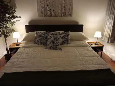 a large bed with two lamps on two tables at Fireside - Waterfront Resort Style Executive Cottage in Kawartha Lakes
