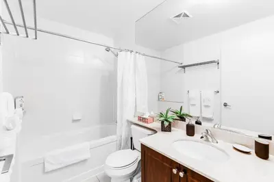 a white bathroom with a sink and a toilet at AOC Suites - High-Rise Condo - City View in Toronto