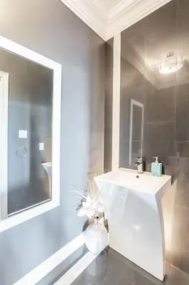 a bathroom with a white sink and a mirror at Beautiful Family Villa, Pond Facing with Huge Backyard in Brampton