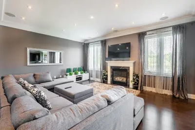 a living room with a large couch and a fireplace at Beautiful Family Villa, Pond Facing with Huge Backyard in Brampton