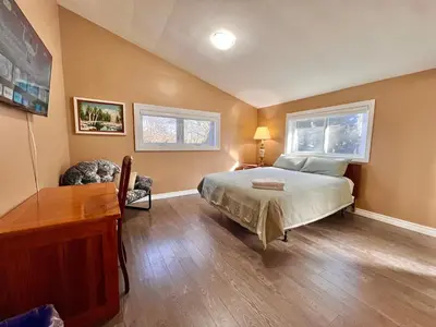 a bedroom with a bed and a desk and two windows at Newly Renovated Home in Central Aurora in Aurora