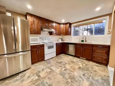 a kitchen with wooden cabinets and stainless steel appliances at Newly Renovated Home in Central Aurora in Aurora