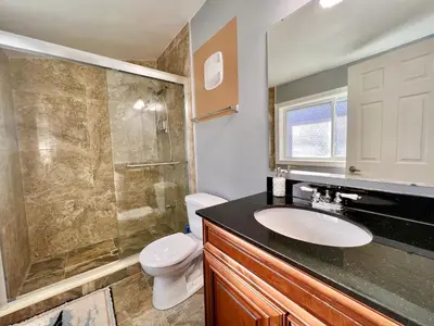 a bathroom with a sink and a shower and a toilet at Newly Renovated Home in Central Aurora in Aurora