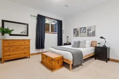 a bedroom with a bed and a dresser and a window at The Parker House Gorgeous Light and Spacious Chalet 86100 in Blue Mountains