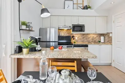 a kitchen with white cabinets and a granite counter top at Blue Mountain The Parker Slopeside in Blue Mountains