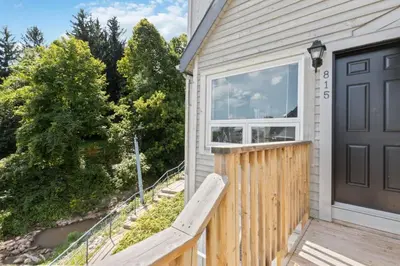 a house with a wooden porch with a black door at Blue Mountain The Parker Slopeside in Blue Mountains