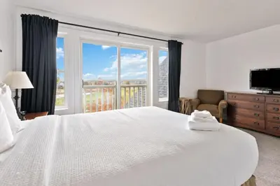 a bedroom with a white bed and a large window at Spectacular Rivergrass Chalet Steps to Blue Mtn in Blue Mountains