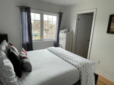 a bedroom with a large white bed with a window at Rest in Quinte West - 25 mins from Batawa Ski Hill in Carrying Place