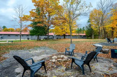 four chairs sitting on a rock in a park at Moira Lake Motel in Madoc