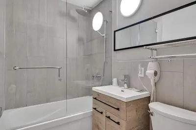a bathroom with a tub and a sink and a shower at Moira Lake Motel in Madoc