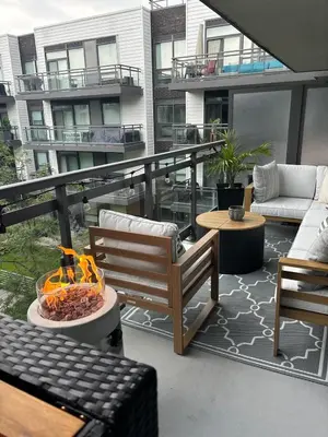 a patio with a couch and chairs on a balcony at Stunning Stayz Luxury 2 King Suite at Friday Harbour Resort Marina Walk & Parking in Innisfil