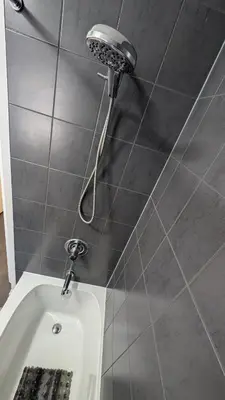 a bath tub with a shower head in a bathroom at Exclusive Townhome near West-Side Trails in Waterloo
