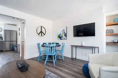 a living room with a table and blue chairs at 