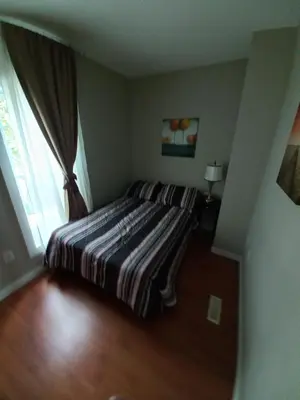 a bedroom with a bed with a striped blanket at Niagara Falls Dream Family Retreat in Niagara Falls
