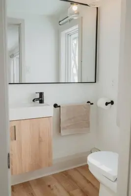 a bathroom with a sink and a mirror and a toilet at Beach House in Niagara in Wainfleet