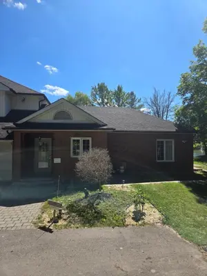 a brick house with a driveway in front of it at Resort style entire guesthouse-2 rooms in Tottenham