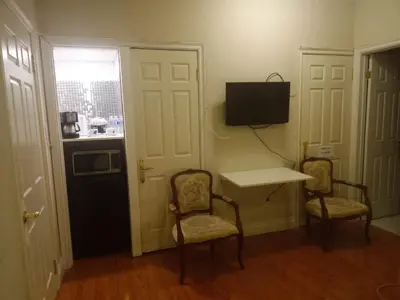 a room with two chairs and a table and a television at Resort style entire guesthouse-2 rooms in Tottenham