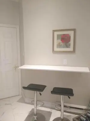 a white room with two stools and a picture on the wall at Resort style entire guesthouse-2 rooms in Tottenham