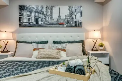 a bedroom with a white bed with two lamps at Vacation Suite in Pickering in Pickering