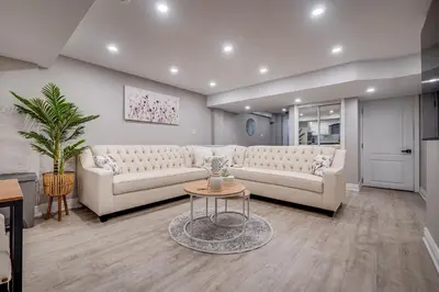 a living room with two white couches and a table at Vacation Suite in Pickering in Pickering