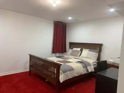 a bedroom with a bed and a red carpet at Guest House Room No 01 in Mississauga