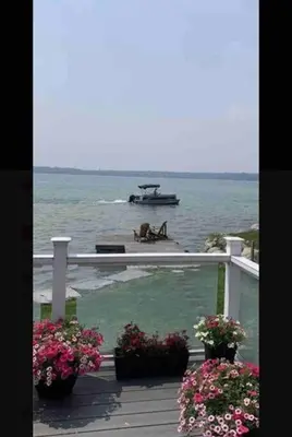 a boat in the water with flowers on a deck at SouthLake Cottage on The Lake. in Washago