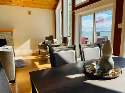 a dining room with a table and chairs at SouthLake Cottage on The Lake. in Washago