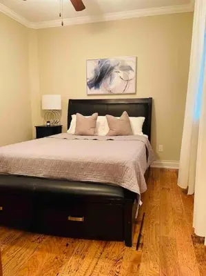 a bedroom with a large bed with a black frame at SouthLake Cottage on The Lake. in Washago