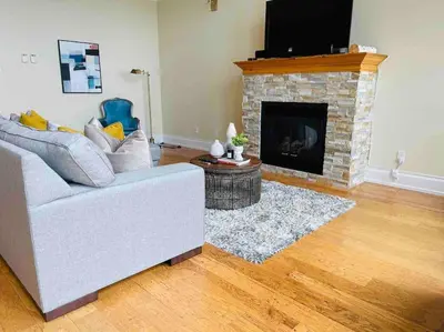 a living room with a couch and a fireplace at SouthLake Cottage on The Lake. in Washago