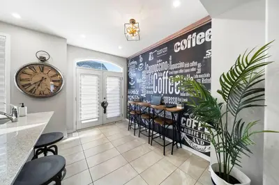 a restaurant with a bar with chairs and a clock at Modern 4 Level home-Game room/Parking/Near Airport in Mississauga