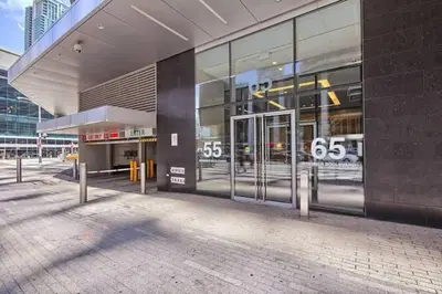 a large glass building with its doors open at Prestigious 2-Bdrm Condo - across from Scotiabank Arena in Toronto