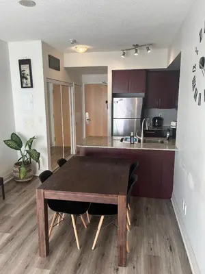 a kitchen with a wooden table in a room at Prestigious 2-Bdrm Condo - across from Scotiabank Arena in Toronto