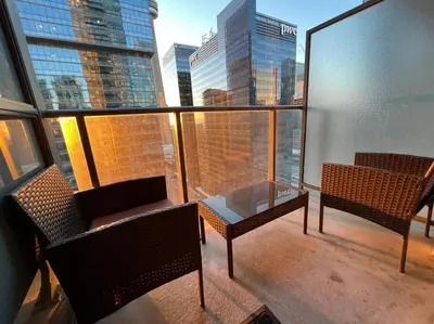 a balcony with a glass table and chairs on a building at Prestigious 2-Bdrm Condo - across from Scotiabank Arena in Toronto