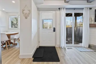 a living room with a white door and a table at Four Peaks - Unit 40A in Collingwood
