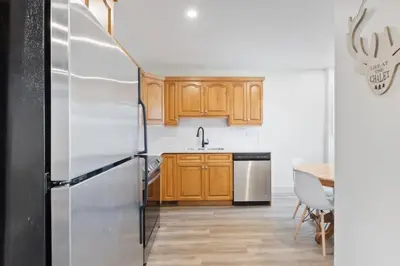 a kitchen with wooden cabinets and a stainless steel refrigerator at Four Peaks - Unit 40A in Collingwood