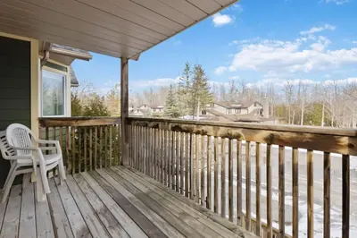 a porch with a white chair on a wooden deck at Four Peaks - Unit 40A in Collingwood