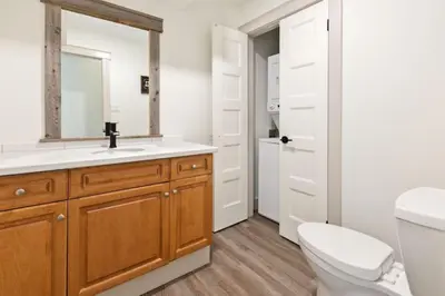 a bathroom with a toilet and a sink with a mirror at Four Peaks - Unit 40B in Collingwood