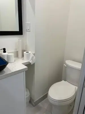 a white bathroom with a toilet and a sink at Mama Gol in Richmond Hill