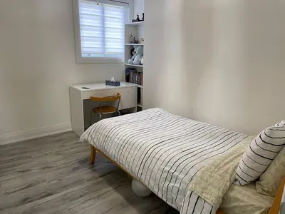 a bedroom with a bed and a desk and a window at Mama Gol in Richmond Hill