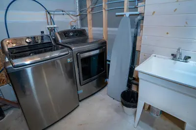 a small kitchen with a stove and a sink at Mountain House in the Heart of Haliburton, Mins to Lake in Haliburton