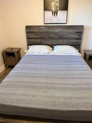 a bedroom with a large bed with a wooden headboard at Marmora Hideaway - Lake front in Marmora