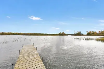 a wooden dock in the middle of a lake at Rustic cottage on Canal Lake in Carden