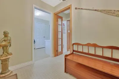 a room with a bed and a hallway with a door at Rustic cottage on Canal Lake in Carden