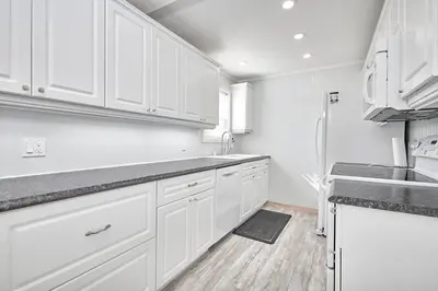 a white kitchen with white cabinets and a sink at Muskoka Honey Harbour 4-Bed Retreat with Hot Tub in Honey Harbor