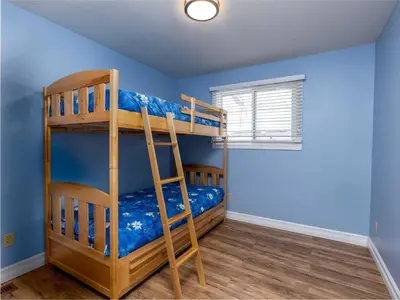 a bedroom with bunk beds in a room with blue walls at Cozy Escape, Kawarthas Cottage With Sauna in Buckhorn